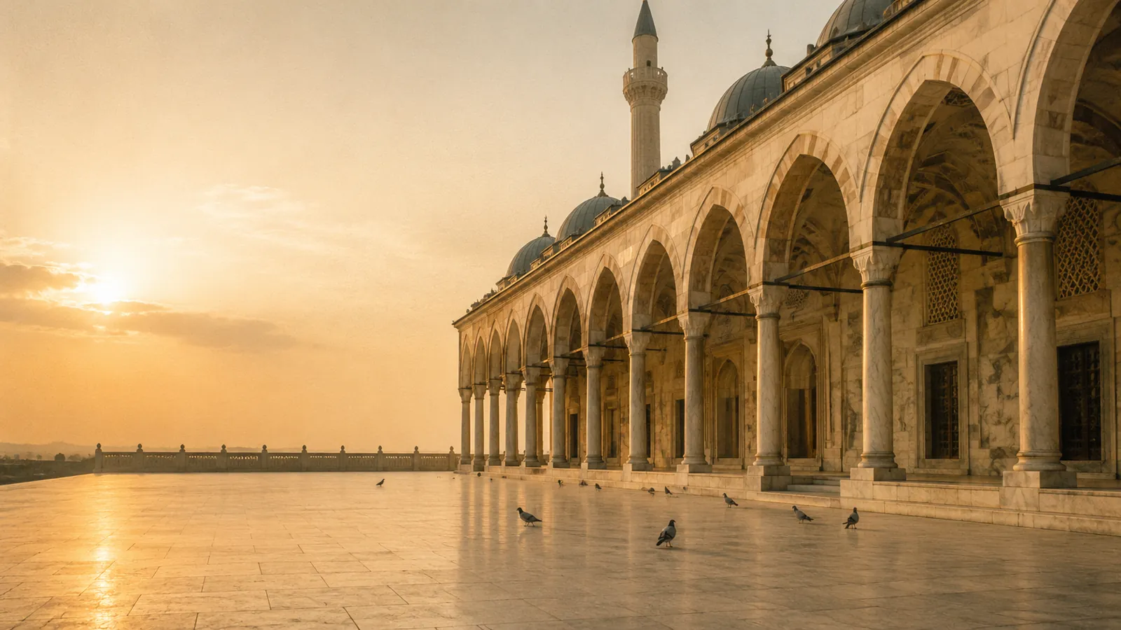 A mosque courtyard with a marble arcade in afternoon sun